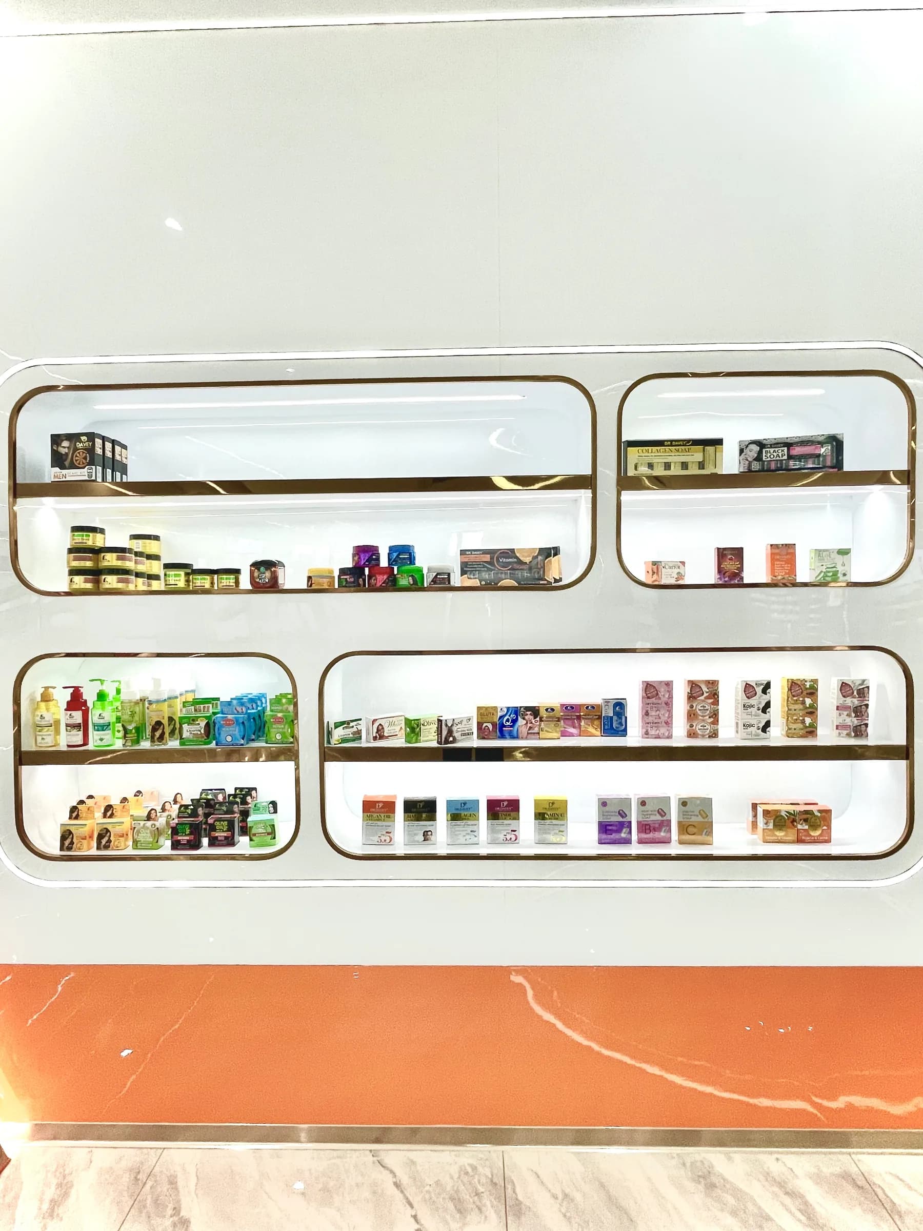 Cosmetic samples arranged in illuminated display niches at the King Metis showroom