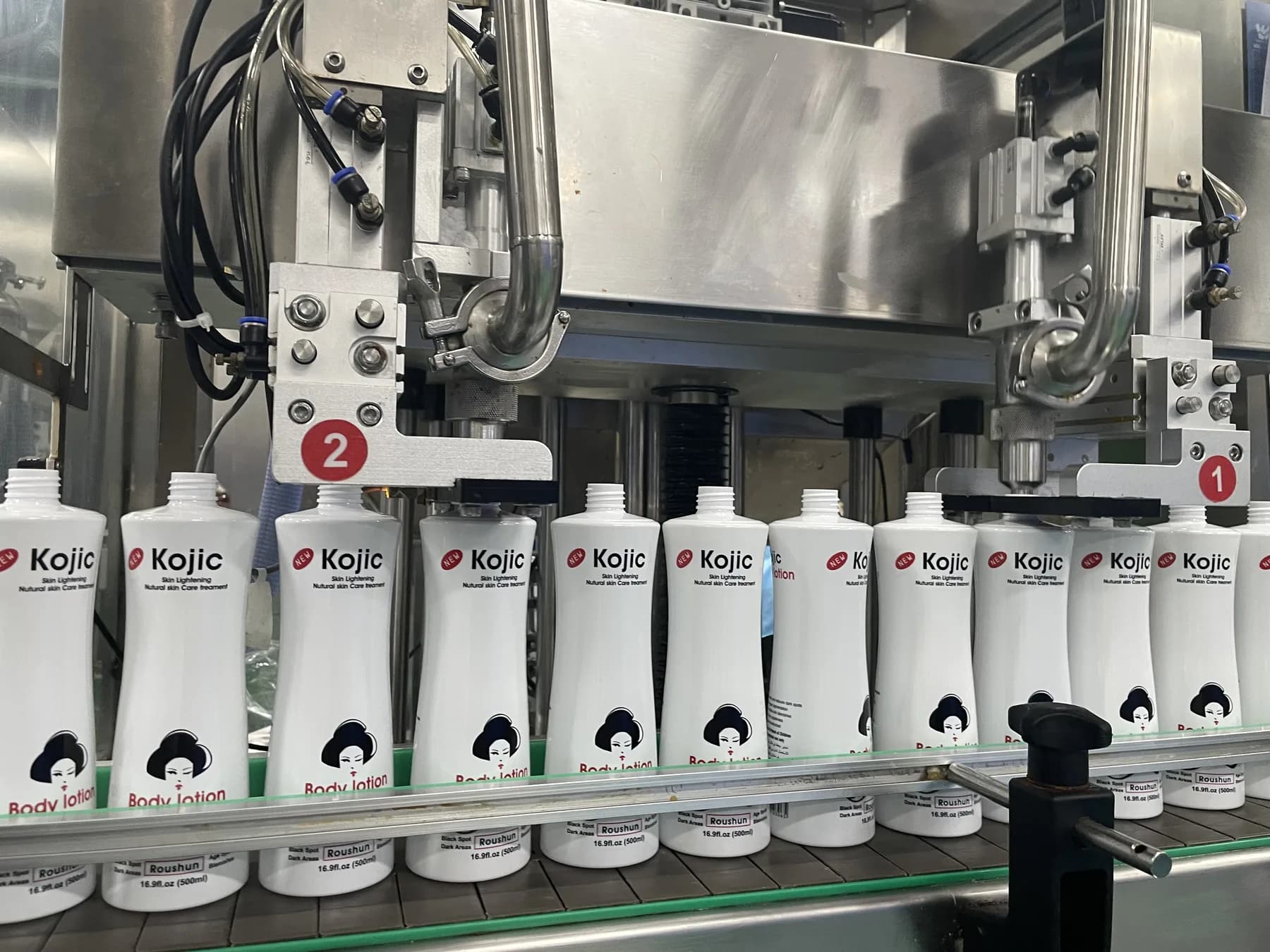 Personal care bottles moving through an automated filling machine at King Metis
